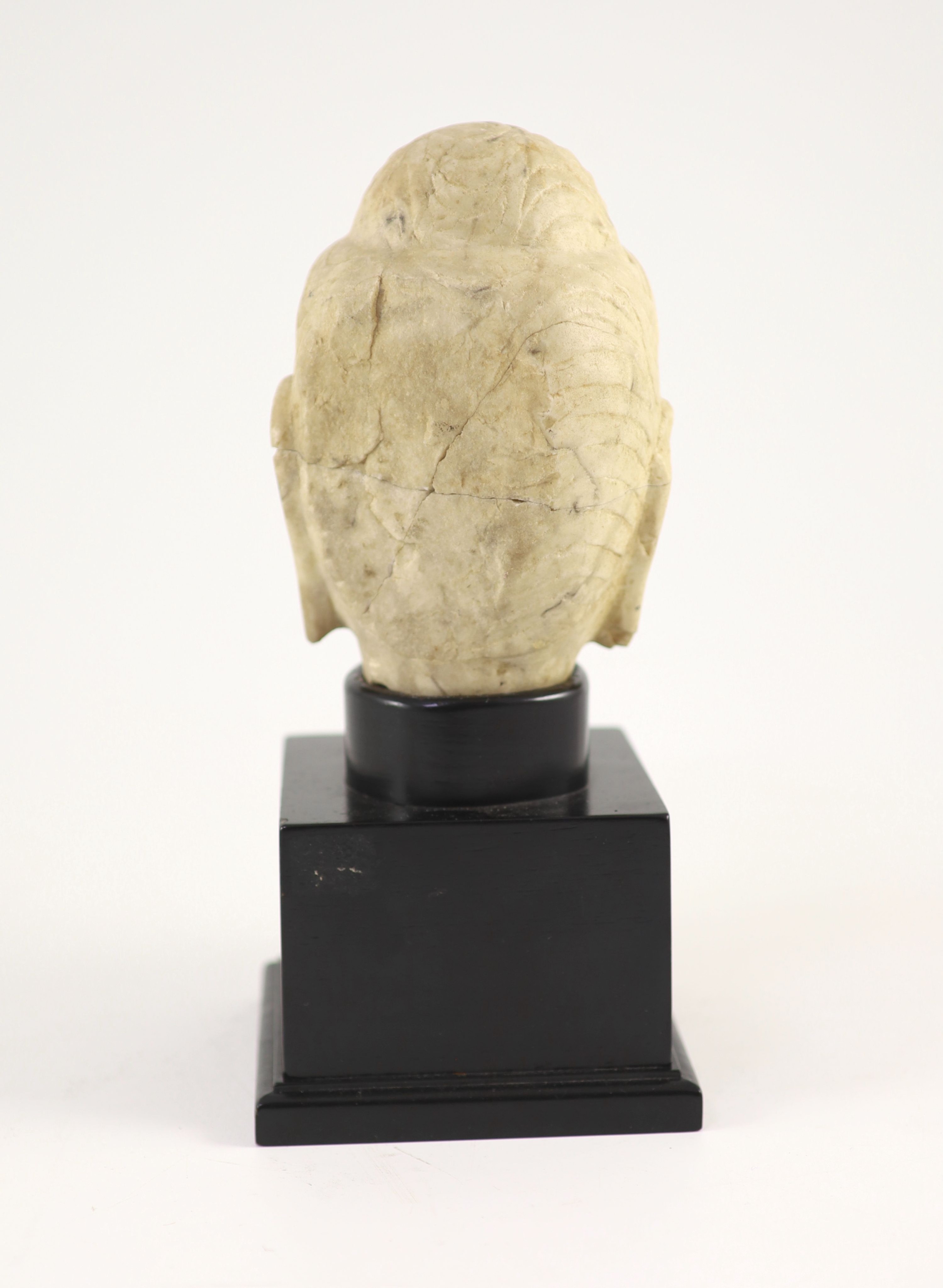 A Chinese carved white marble head of Buddha, Tang dynasty (618-907 AD), 16 cm high excluding later stand, old repairs